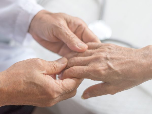 Geriatric doctor or geriatrician concept. Doctor physician hand on happy elderly senior patient to comfort in hospital examination room or hospice nursing home or wellbeing county. Geriatric doctor or geriatrician concept. Doctor physician hand on happy elderly senior patient to comfort in hospital examination room or hospice nursing home or wellbeing county.