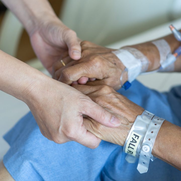 Elderly senior aged patient on bed with geriatric doctor holding hands for trust and nursing health care, medical treatment, caregiver and in-patient ward healthcare in hospital Elderly senior aged patient on bed with geriatric doctor holding hands for trust and nursing health care, medical treatment, caregiver and in-patient ward healthcare in hospital